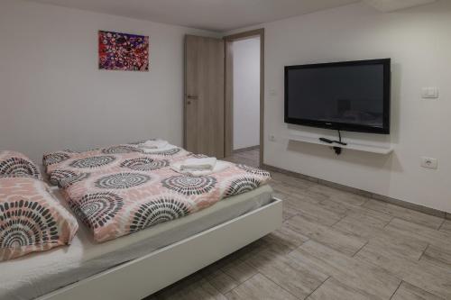 a bedroom with a bed and a flat screen tv at Apartment For You in Bled