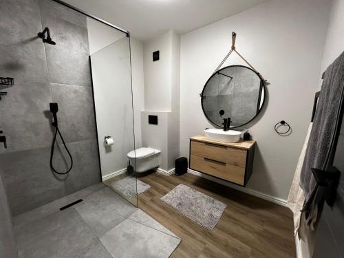 a bathroom with a shower and a sink and a mirror at Mo's Explorer Cape Town Vacation Apartment in Cape Town