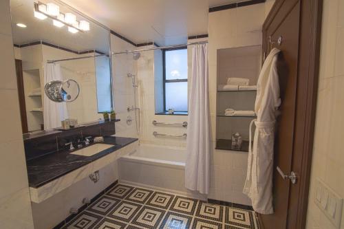 uma casa de banho com uma banheira, um lavatório e um chuveiro em Iroquois New York Times Square em Nova York