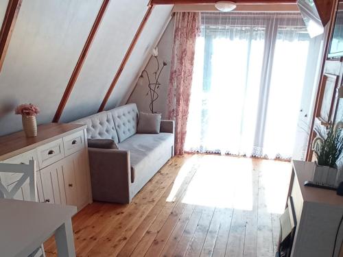 a living room with a couch and a large window at Domek na Mazurach Leśne Zacisze in Ostaszewo