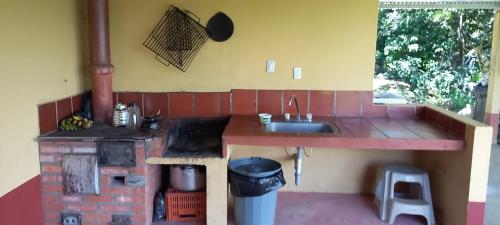 a kitchen with a sink and a brick stove at Finca Campestre Villa Carilina in Curití