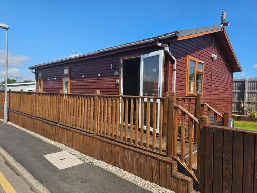 a house with a wooden fence in front of it at 2 Bed Cabin - Sleeps 4 - Pets - 5 min to Beach in Bridlington