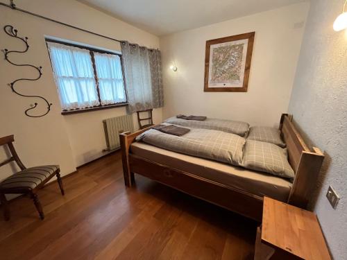 - une chambre avec un lit, une chaise et une fenêtre dans l'établissement Da Gabriella, à Courmayeur