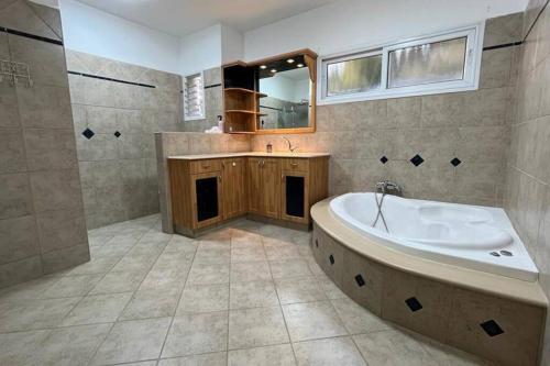 a large bathroom with a tub and a sink at גבוה בגלבוע in Gan Ner