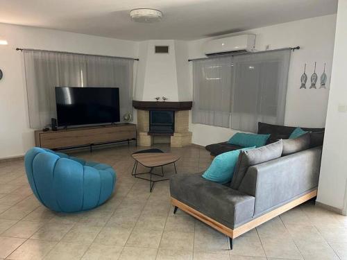 a living room with a couch and a tv at גבוה בגלבוע in Gan Ner