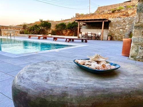 miska jedzenia na stole obok basenu w obiekcie Villa Alba Mykonos w mieście Agios Sostis Mykonos