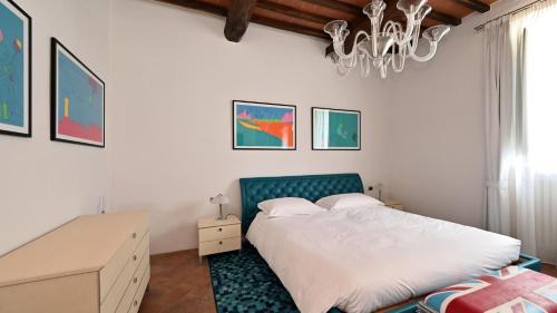 1 dormitorio con cama, escritorio y lámpara de araña en Casa Boccaccio, en Gaiole in Chianti