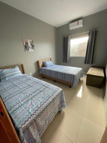 1 dormitorio con 2 camas y ventana en DUNAS RESIDENCE CASA 13 Santo Amaro - Lençóis Maranhenses, en Santo Amaro