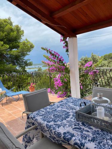 a table and chairs on a patio with a view of the ocean at Apartments Hortenzija in Maslinica