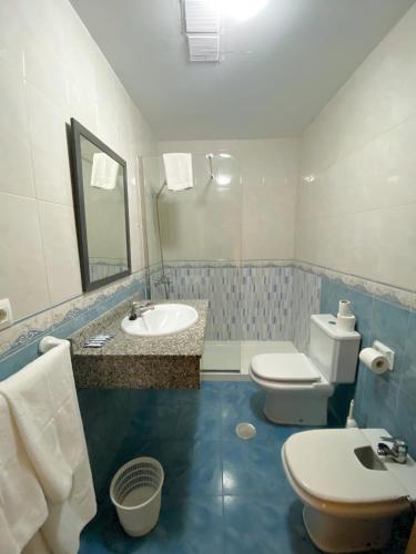 a blue and white bathroom with a sink and a toilet at Apartamentos Maracay in Roquetas de Mar