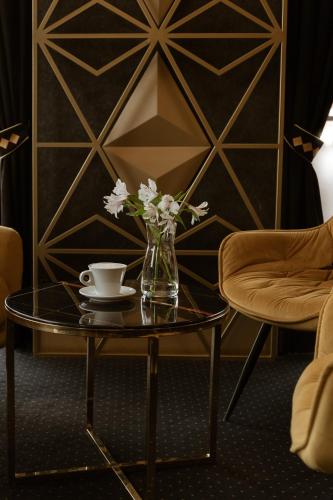 a glass vase with flowers on a glass table at Aparthotel Prestige & SPA in Zakopane