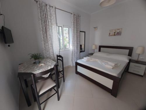 Schlafzimmer mit einem Bett, einem Tisch und einem Schreibtisch in der Unterkunft MyKsamil Apartments in Ksamil