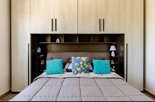 a bedroom with a large bed with blue pillows at Il Casello Country House in Sciacca