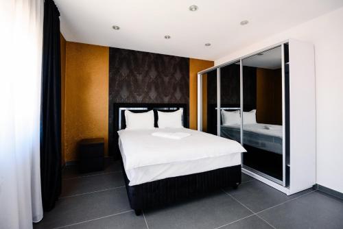 sypialnia z dużym białym łóżkiem i lustrem w obiekcie Concept Villa w mieście Livezeni