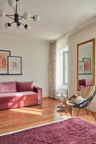 a living room with a pink couch and a mirror at Best Apartments on Kyryla & Mefodia in Mukacheve