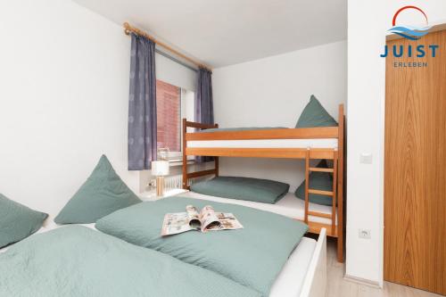 a bedroom with two bunk beds and a book at Haus Hamburg 181 Wohnung 1 in Juist
