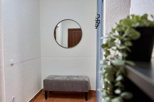 a hallway with a round mirror and a stool at Best Apartments on Kyryla & Mefodia in Mukacheve
