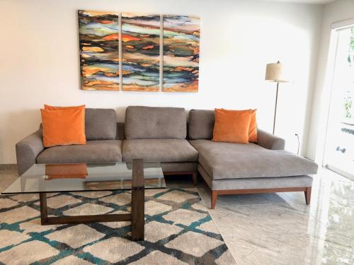 a living room with a gray couch and orange pillows at 230A South Finger in Jolly Harbour