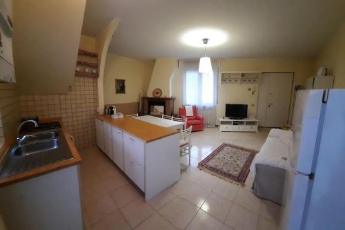 uma cozinha e sala de estar com um frigorífico e um lavatório em Ildi's Guest House em Seriate