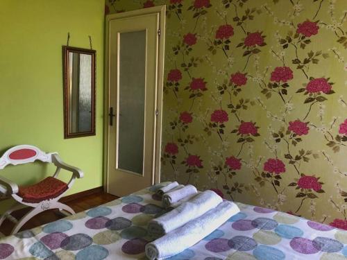 um quarto com uma cama e um papel de parede florido em Ildi's Guest House em Seriate