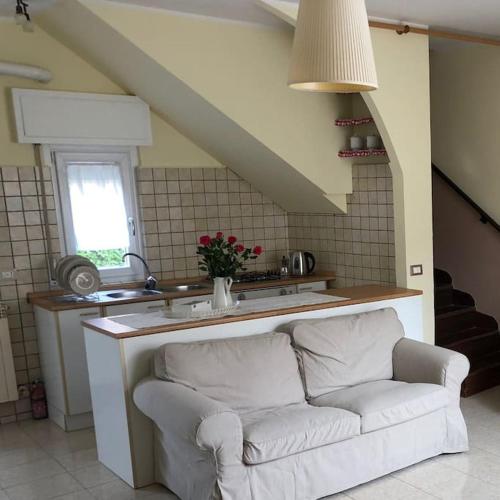 a living room with a white couch in a kitchen at Ildi's Guest House in Seriate