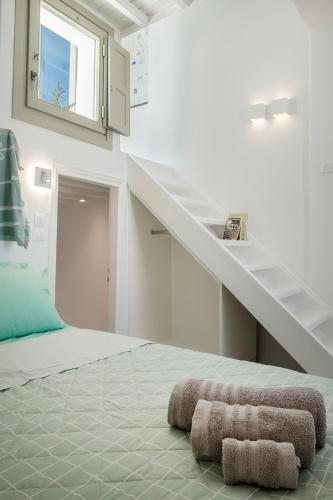 a bedroom with a staircase and two towels on the floor at Mykonos Alley Stars - Secret Khora - 360 View in Mýkonos City