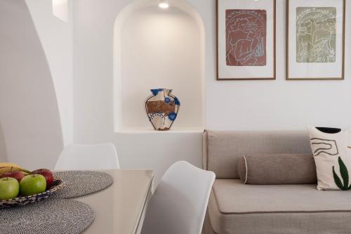 a living room with a couch and a bowl of apples on a table at Mykonos Alley Stars - Secret Khora - 360 View in Mýkonos City