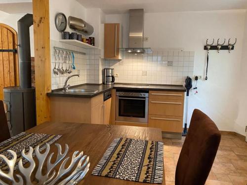 eine Küche mit einem Holztisch und einem Waschbecken in der Unterkunft Waldheimat - Ferienhaus Nürburg in Nürburg