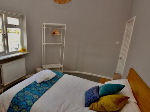 een slaapkamer met een bed met kussens erop bij Stephen's Cheltenham apartment in Cheltenham
