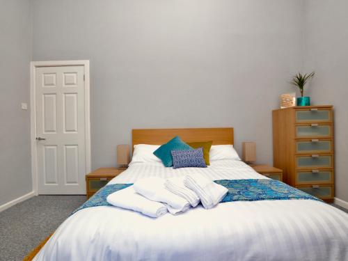 een slaapkamer met een bed met handdoeken erop bij Stephen's Cheltenham apartment in Cheltenham