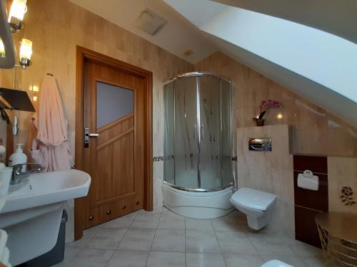 een badkamer met een douche, een toilet en een wastafel bij Dom Gościnny u Szymona in Wrzosowo
