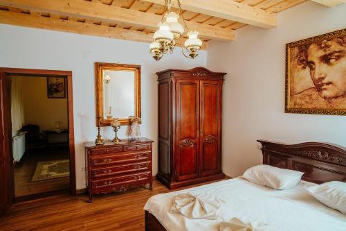 a bedroom with a bed and a dresser and a mirror at Castel Haller in Ogra