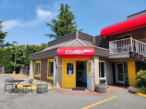 a restaurant with a yellow door and a table at Grantview Inn in Surrey