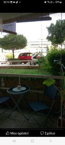un patio con una mesa y 2 sillas y un coche en 56m2 nea smyrni, en Atenas