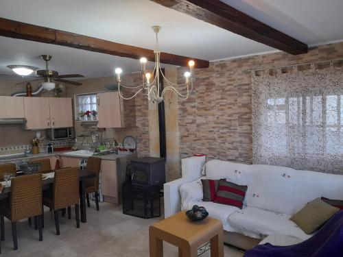 耶斯特的住宿－Casa Rural del Saz，一间带白色沙发的客厅和一间厨房