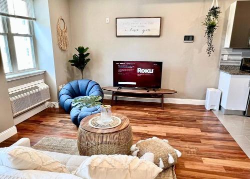 Una sala de estar con un sofá y un televisor. en 503 Bohemian Romance Apartments in center city, en Filadelfia