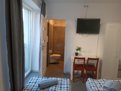 a bedroom with a bed and a table and a bathroom at Firstroom Gdańsk in Gdańsk