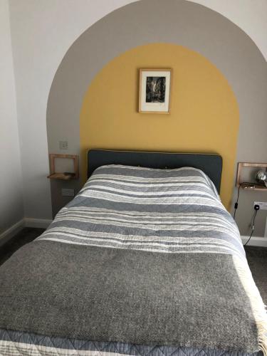 una camera con un letto con una parete gialla di Woodcliff a Birkenhead