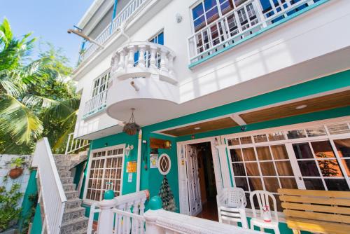 Casa con fachada azul y verde y balcón. en Apartamentos Turísticos El Conquistador, en San Andrés