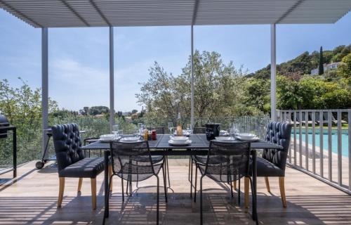 a table and chairs on a patio with a pool at Villa KEY WEST & Unique & Piscine & Vue Mer & Clim in Mougins