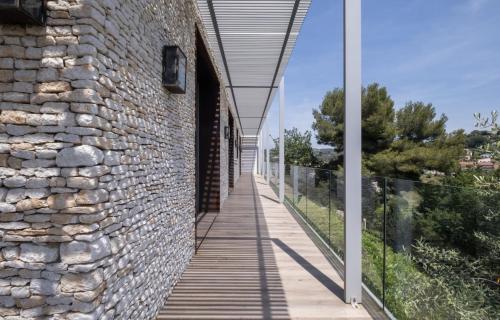 un mur en pierre avec une passerelle à côté d'un bâtiment dans l'établissement Villa KEY WEST & Unique & Piscine & Vue Mer & Clim, à Mougins