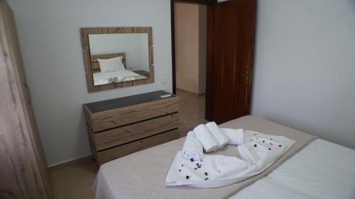 a bedroom with a bed with a dresser and a mirror at VILLA KONSTADINE in Asprovalta