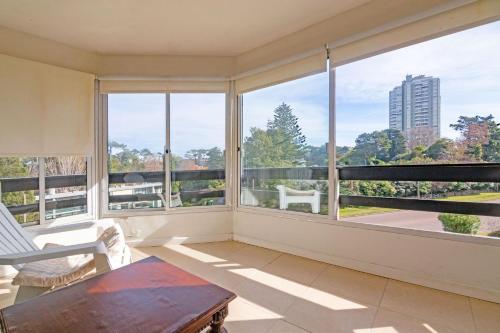 a living room with large windows and a table at Oceana Suites BoraBora in Punta del Este