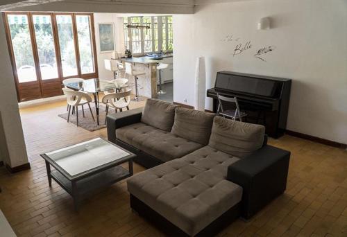 - un salon avec un canapé et un piano dans l'établissement Charmant Rez de Villa climatisé rénové, 90m2 avec parking, à Cassis