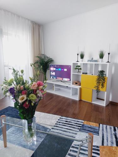 una sala de estar con un jarrón de flores sobre una mesa en Cozy apartment in the center of Bucharest, en Bucarest