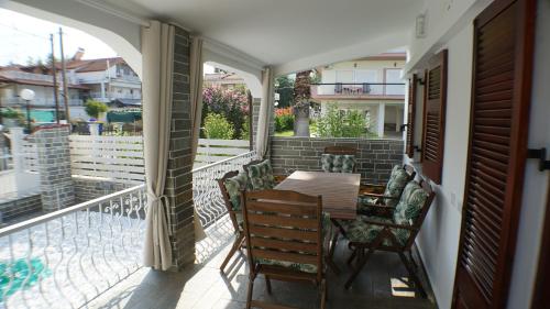 a porch with a table and chairs on a balcony at VILLA KONSTADINE in Asprovalta
