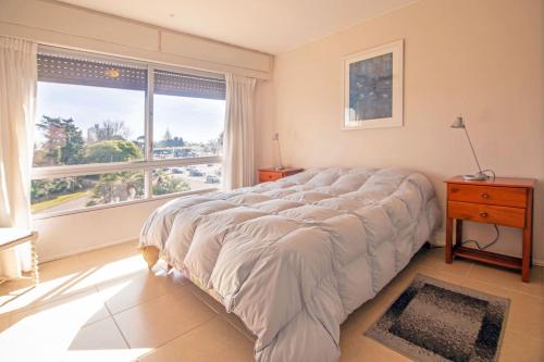 uma cama grande num quarto com uma janela grande em Oceana Suites en Bora Bora, con vistas a la ciudad em Punta del Este