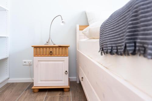 a bedroom with a bed with a night stand next to it at Geiseltalsee Haus am See mit Wallbox in Mücheln