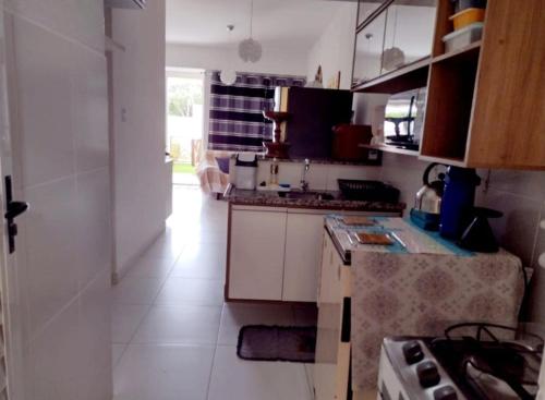 a kitchen with white cabinets and a stove top oven at Refúgio a 20km de Salvador na praia de Jacuípe in Camaçari