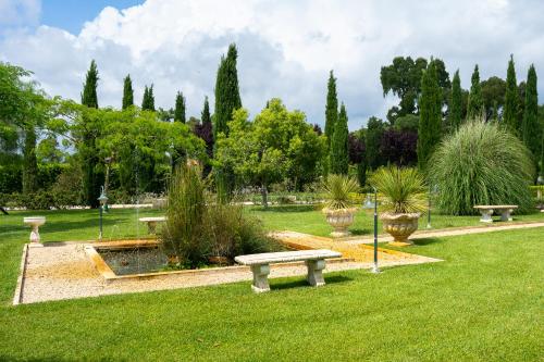 a park with benches and a pond and trees at Casale Delle Ronde B&B in Latina
